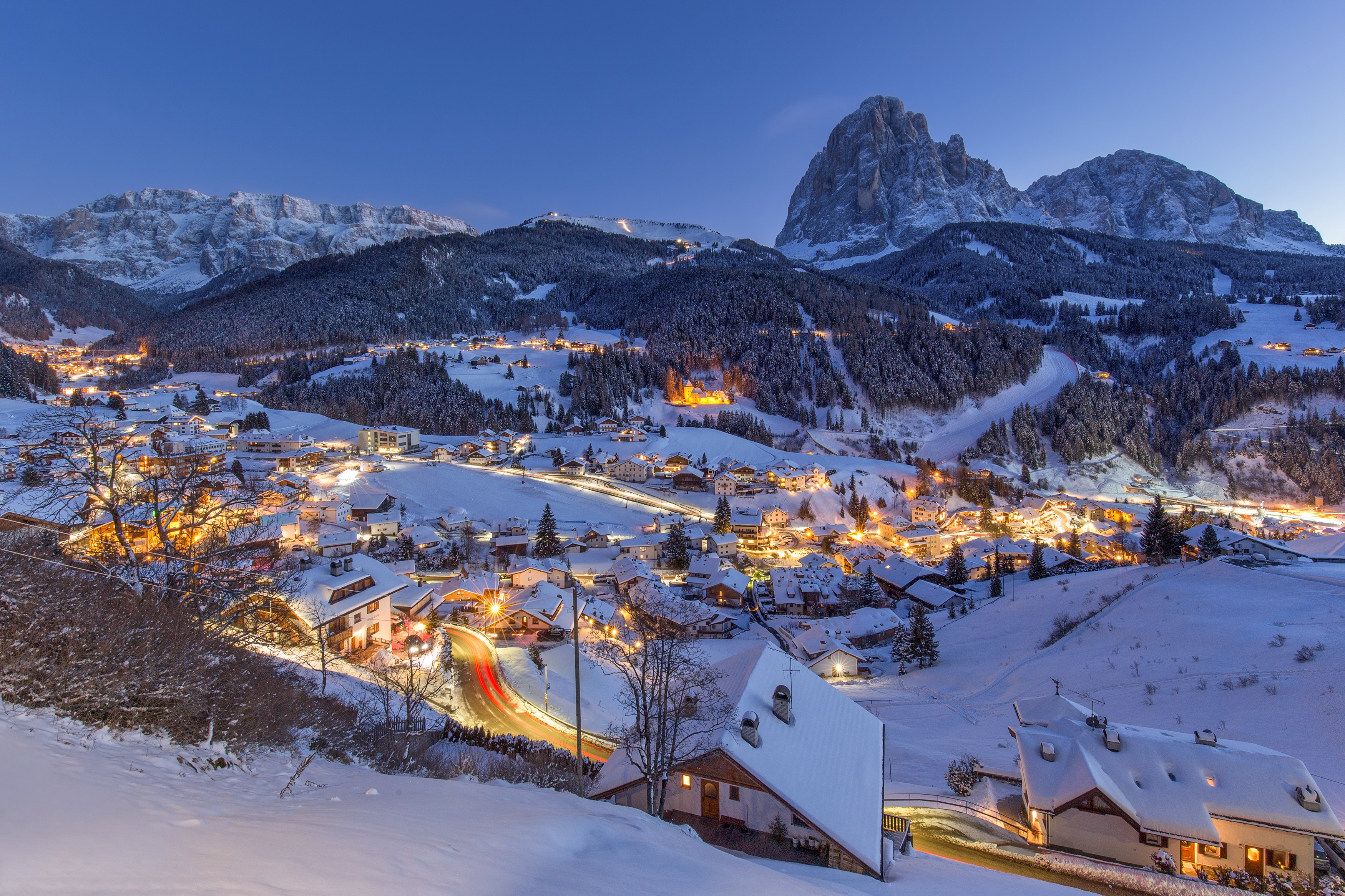 Village tyrolien enneigé au crépuscule, lumières dans la vallée